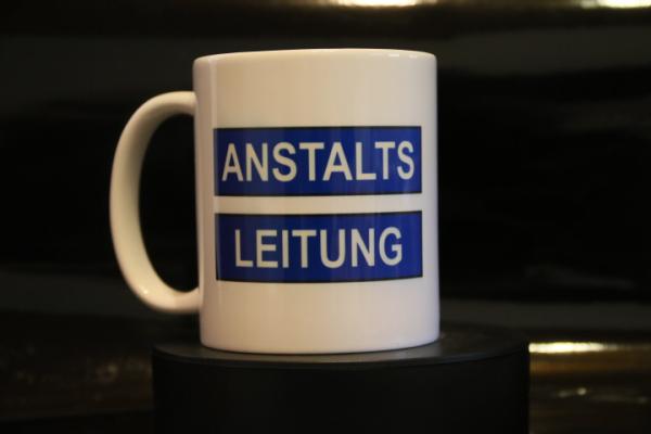 Weiße Tasse mit Spruch "ANSTALTSLEITUNG"